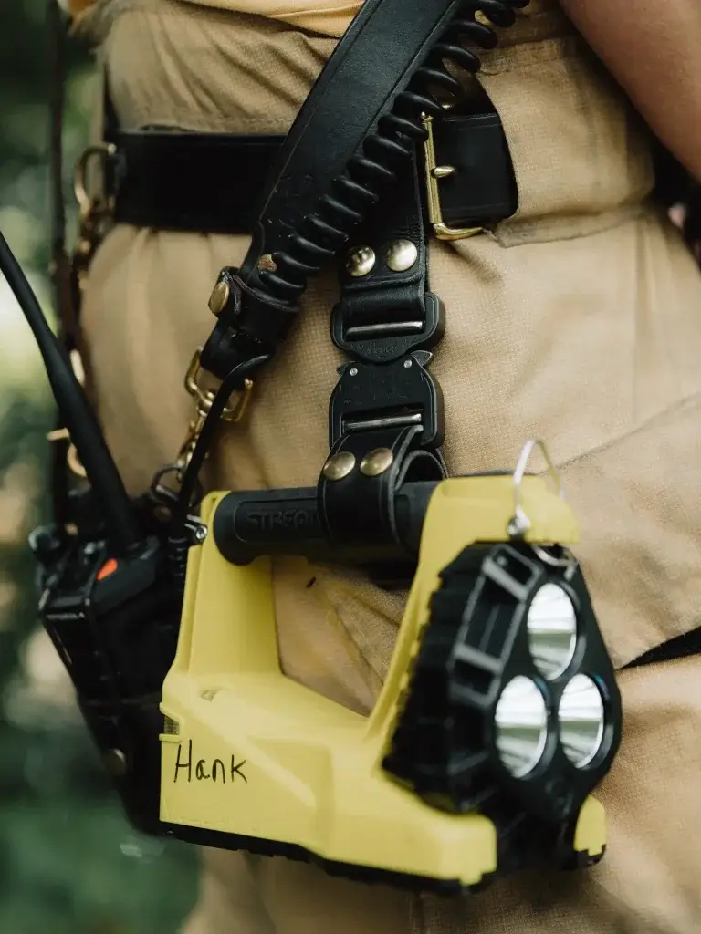 a firefighter wears a leather box light rig attached to his leather turnout belt with his stream light vulcan flashlight for the fireservice