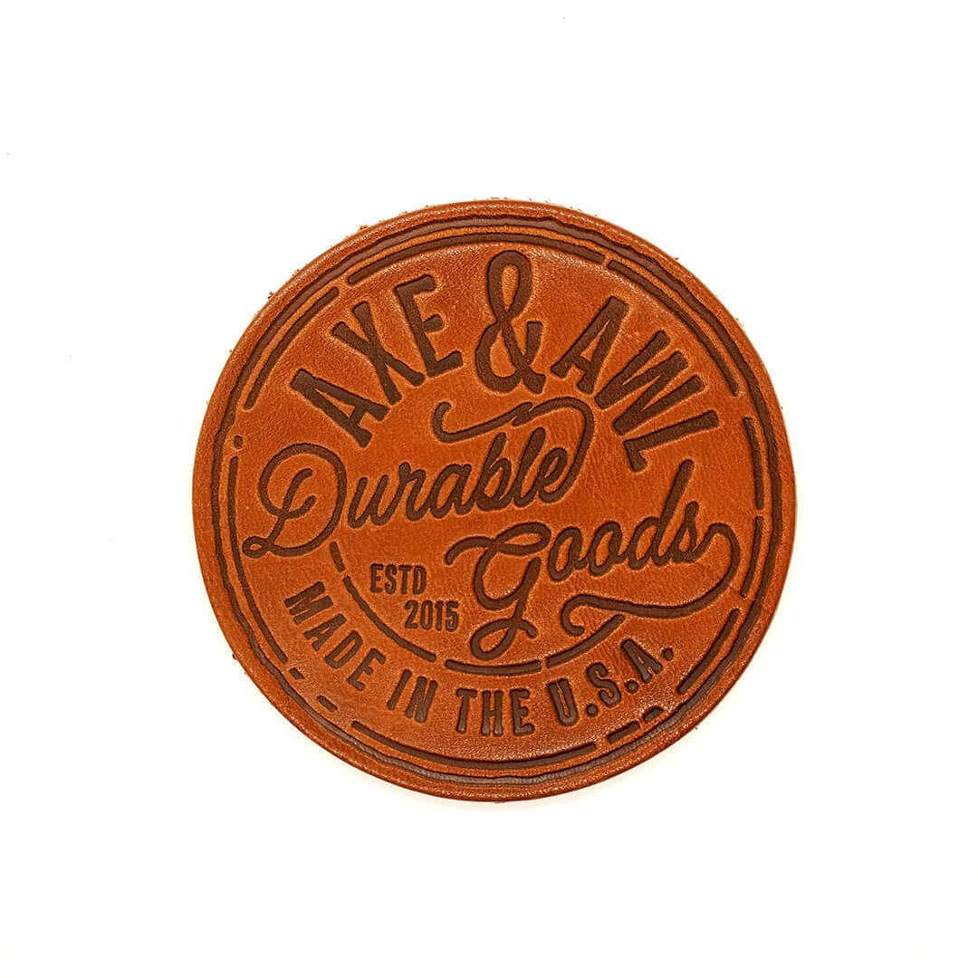 Round Leather Coaster in q tan leather with durable goods logo