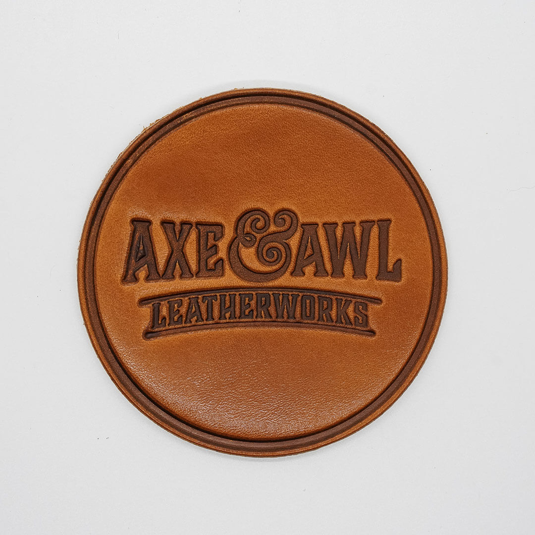 Round Leather Coaster in q tan leather with word mark logo