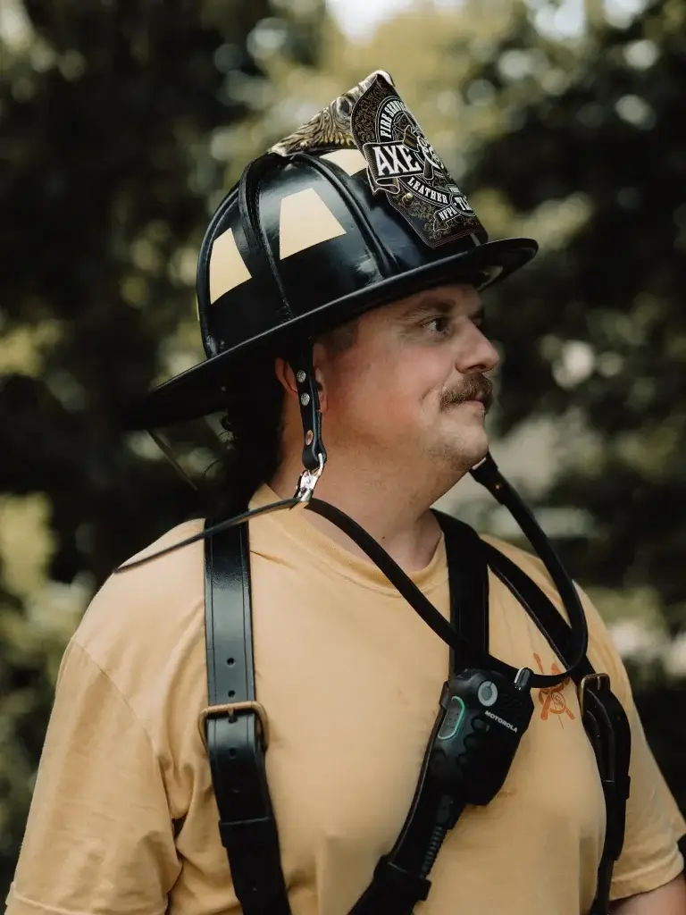 a fire fighter wears a two piece leather chin strap made by axe and awl leatherworks with his phenix tl-2 leather fire helmet