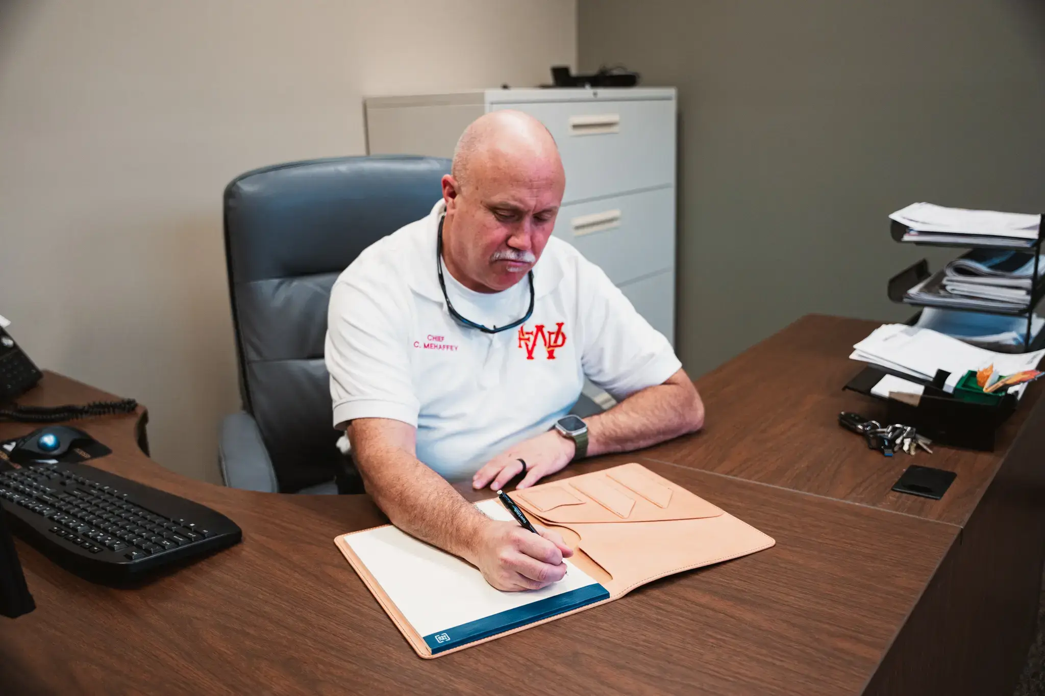 fire chief at waynesville fire department using a full-grain leather padfolio hand crafted by axe and awl leatherworks