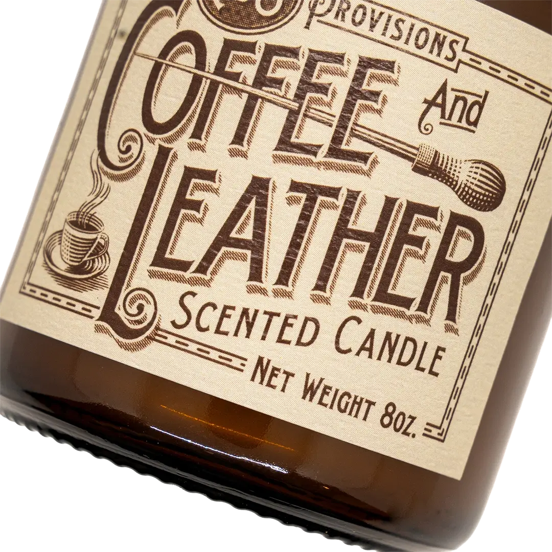 Close-up of C&S Provisions Coffee & Leather scented candle label on an amber glass jar