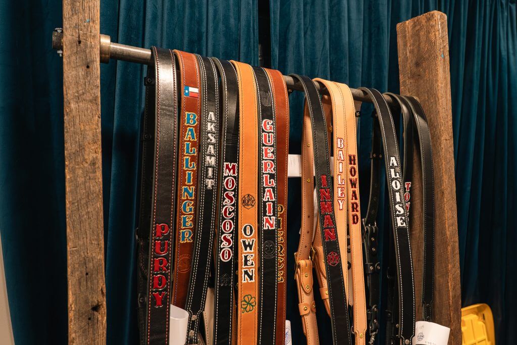 leather radio straps hanging on a wood a steel radio strap display