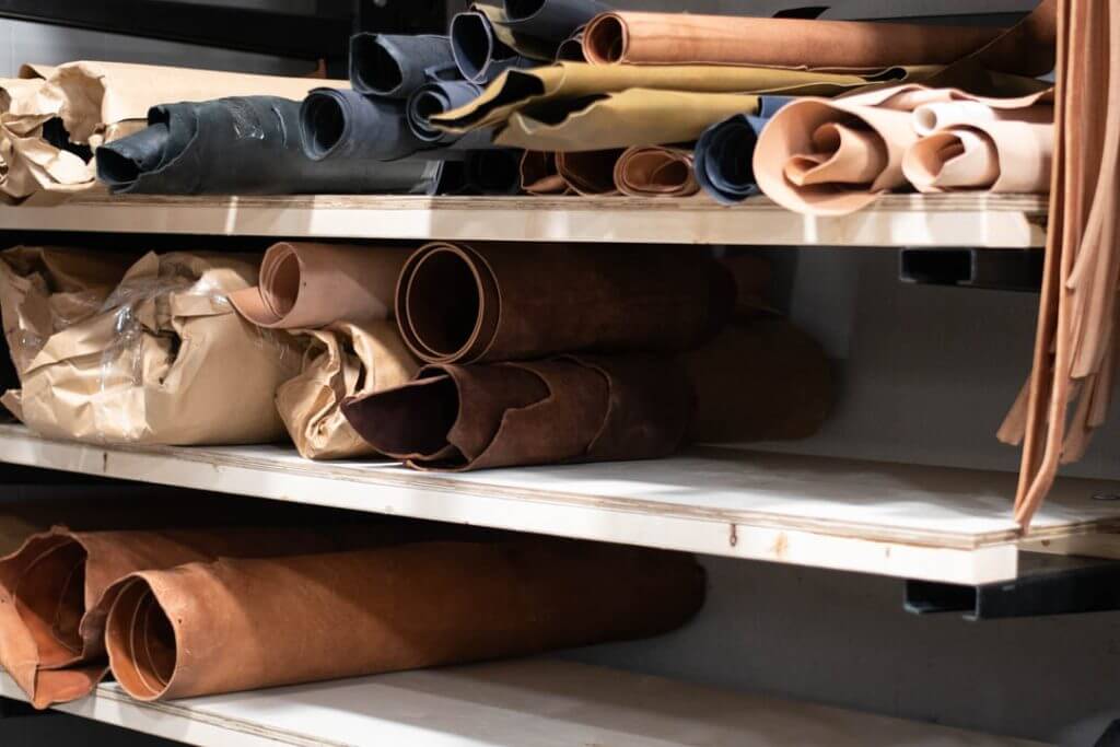 Rolls of leather on a shelf ready to be cut into firefighter radio straps and leather belts