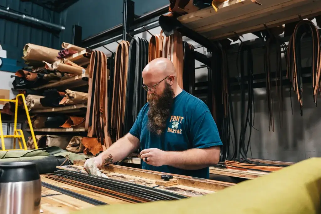 leather crafter dan burnishes fire service belts in the axe and awl workshop in waynesville, nc