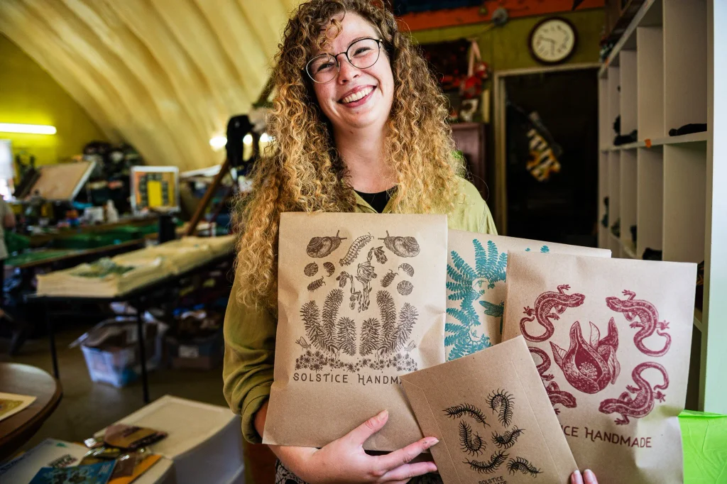 solstice handmade holding up screen printed artwork in asheville, nc