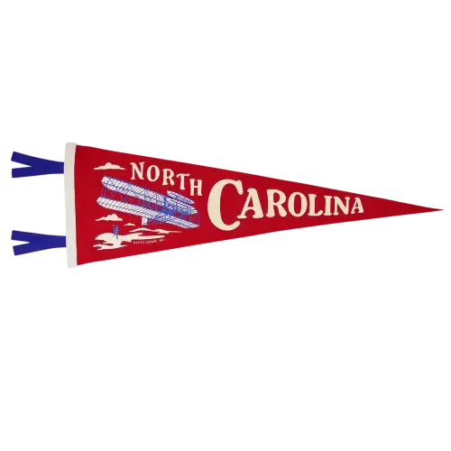 A red felt pennant with North Carolina and the Wright Brothers Flyer on it.